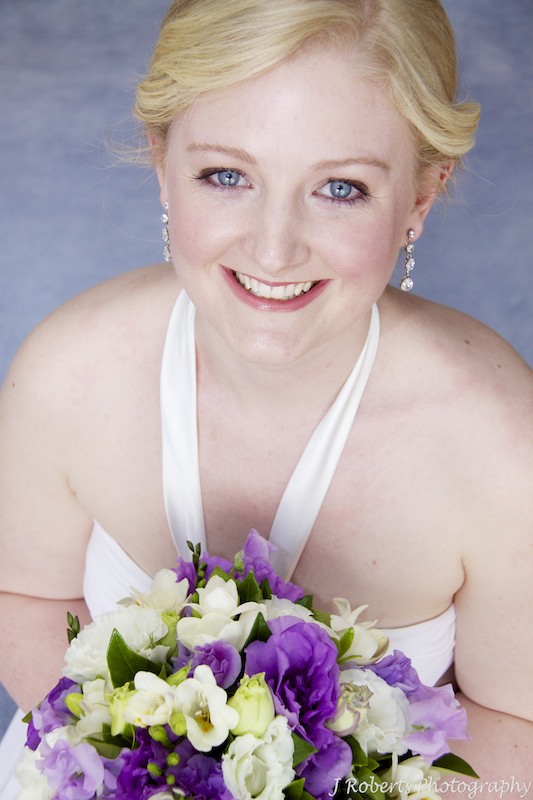 Bride looking up at camera with flowers - wedding photography sydney
